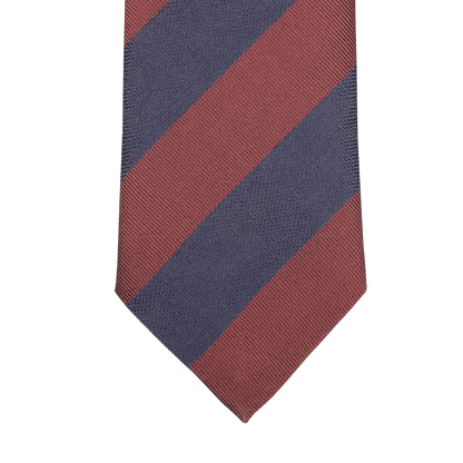A detailed view of the Rust Blue Striped Silk Tie by Seaward & Stearn, featuring diagonal maroon and navy blue stripes set against a light gray background, expertly handcrafted in England.