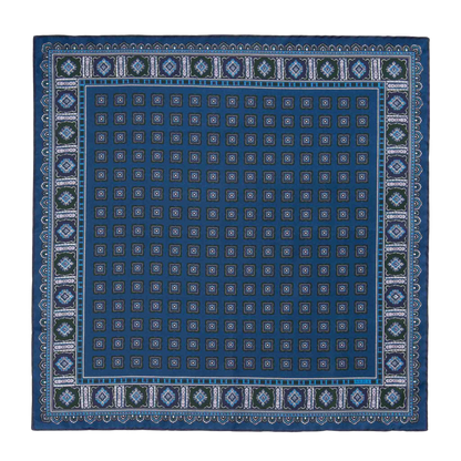 The Salt Primitivo Silk Pocket Square by Sera Fine Silk is a blue square scarf adorned with an intricate geometric pattern combining diamonds and squares, highlighted by a contrasting border. Crafted from luxurious Como silk, this piece is versatile enough to serve as a sophisticated pocket square.