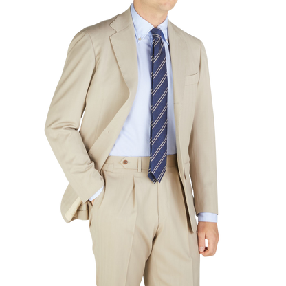 A man wearing a tan suit and Silvio Fiorello's Blue Striped Silk Cotton Wool Tie.