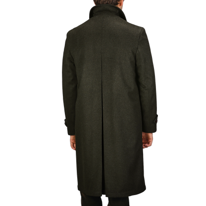 A person wearing a Steinbock Dark Green Wool Alpaca Loden Coat stands with their back turned to the camera.