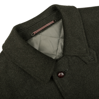 Steinbock's Dark Green Wool Alpaca Loden Coat exudes a refined style, featuring a quilted interior, pointed collar, and a single visible leather football button on the front.