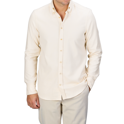 A man wearing a Cream Cotton Flannel Slimline BD Shirt by Stenströms stands confidently with one hand in his pocket against a gray background.