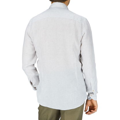 The man is wearing a white Light Grey Striped Linen Stenströms shirt and khaki pants, seen from the back.