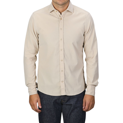 A person dressed in a Stenströms Light Beige Cotton Corduroy Slimline Shirt and dark jeans, standing against a plain gray background.