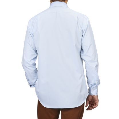 Someone wearing a Light Blue Cotton Twill Fitted Body Shirt by Stenströms, paired with brown pants, is viewed from the back.