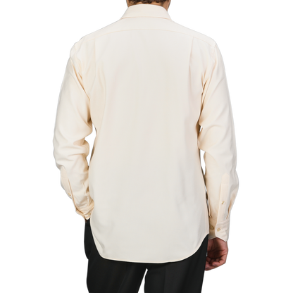 Rear view of a person wearing the Off-White Cotton Flannel Fitted Body Shirt by Stenströms with mother-of-pearl buttons, paired with dark pants against a neutral background.