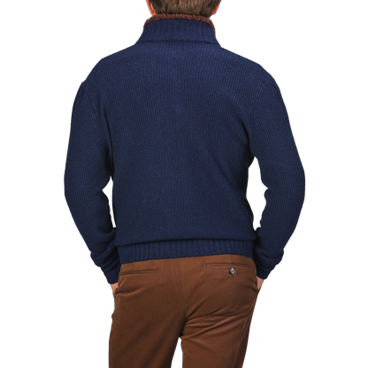 A person in a Royal Blue Cashmere Fur Collar Cardigan by Stile Latino and brown trousers, viewed from behind, stands against a neutral background.