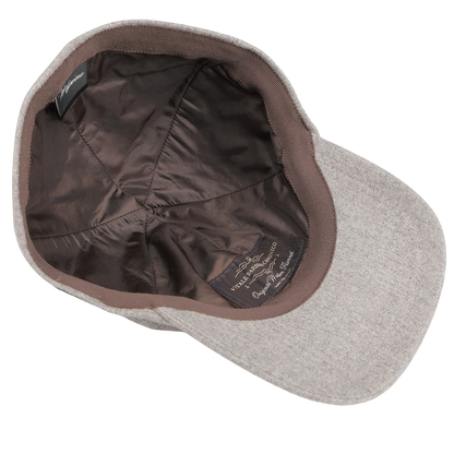Beige wool baseball cap turned inside out, highlighting the elegance of its satin lining and label. Crafted from pure wool flannel by Vitale Barberis Canonico for Wigéns, this cap is as stylish on the inside as it is on the outside.