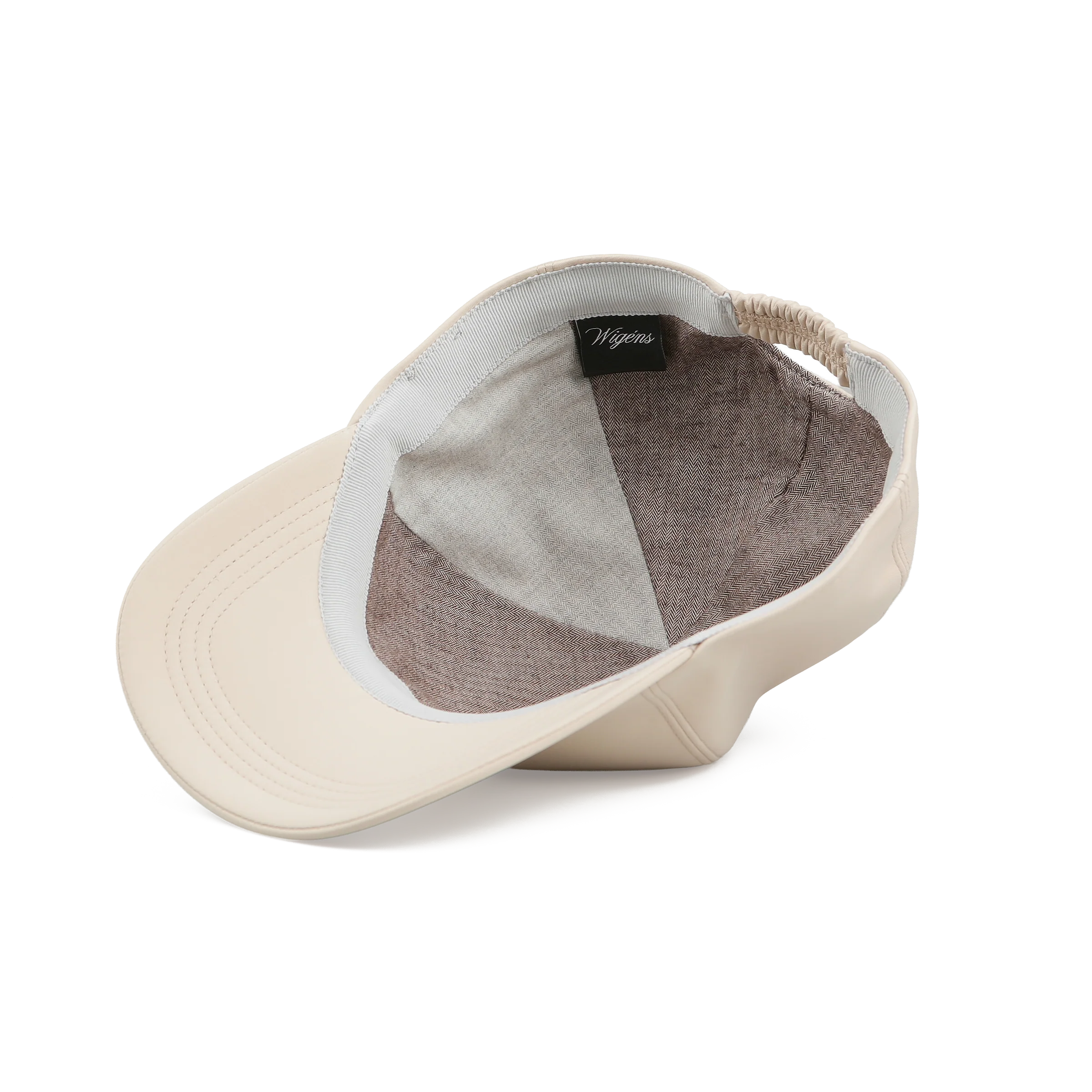 A cream microfibre baseball cap by Wigéns is displayed inside out, showing a brown sport twill lining, a black tag with white Wigéns script, an elastic back band, and visible brim stitching on a plain white background. , available at Richard Gelding Mayfair