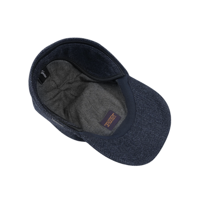 A Dark Blue Herringbone Loro Piana Wool Baseball Cap by Wigéns shown from an overhead angle, displaying its grey inner lining and a fabric label inside, crafted from wool woven in Italy.