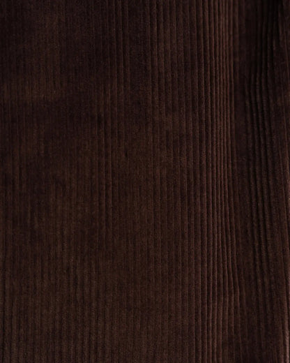 A close-up view of the dark brown fabric of Cavour Brown Wide Leg Pleated Corduroy Trousers, featuring vertical, raised ridges with deep shadows between the velvet-like lines. , available at Richard Gelding Mayfair