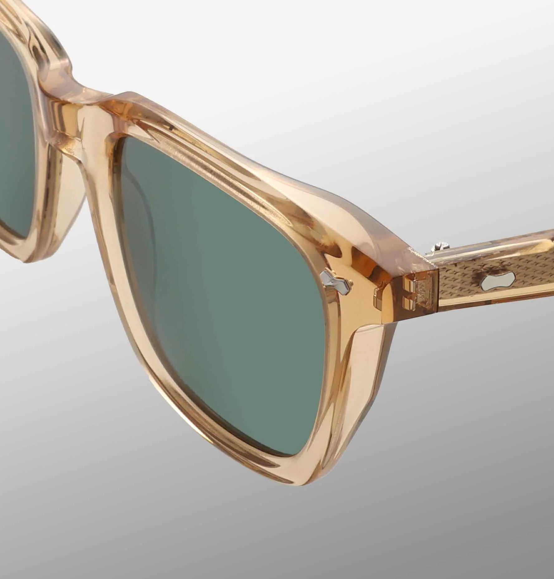 Close-up of TBD Eyewear's Carré Eco Champagne | Bottle Green sunglasses with translucent beige square frames, dark green lenses, subtle shine, and a small silver detail on the temple against a light gray gradient background. , available at Richard Gelding Mayfair