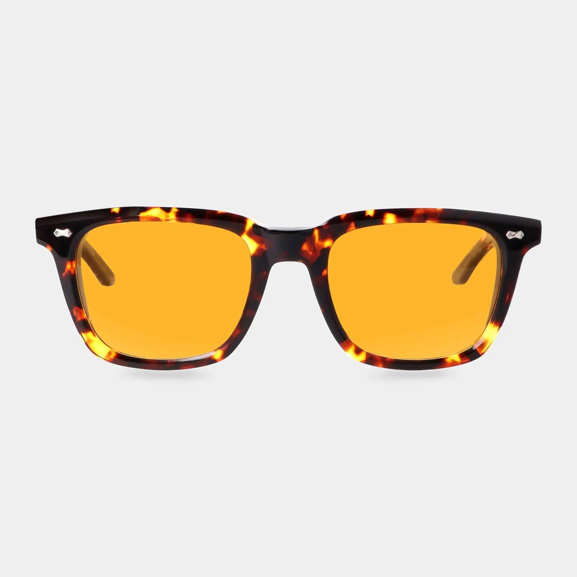 The Carré Eco Dark Havana | Orange sunglasses by TBD Eyewear feature a tortoiseshell frame and bright orange-yellow tinted lenses, shown facing forward on a plain light gray background. , available at Richard Gelding Mayfair