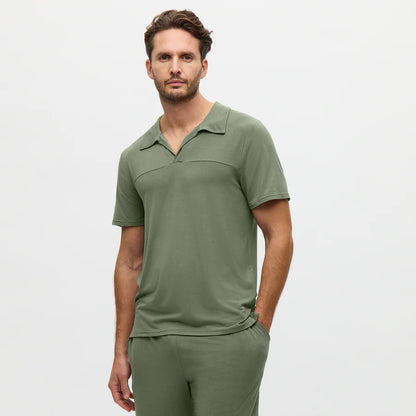 Man wearing a green polo shirt and pants on a white background