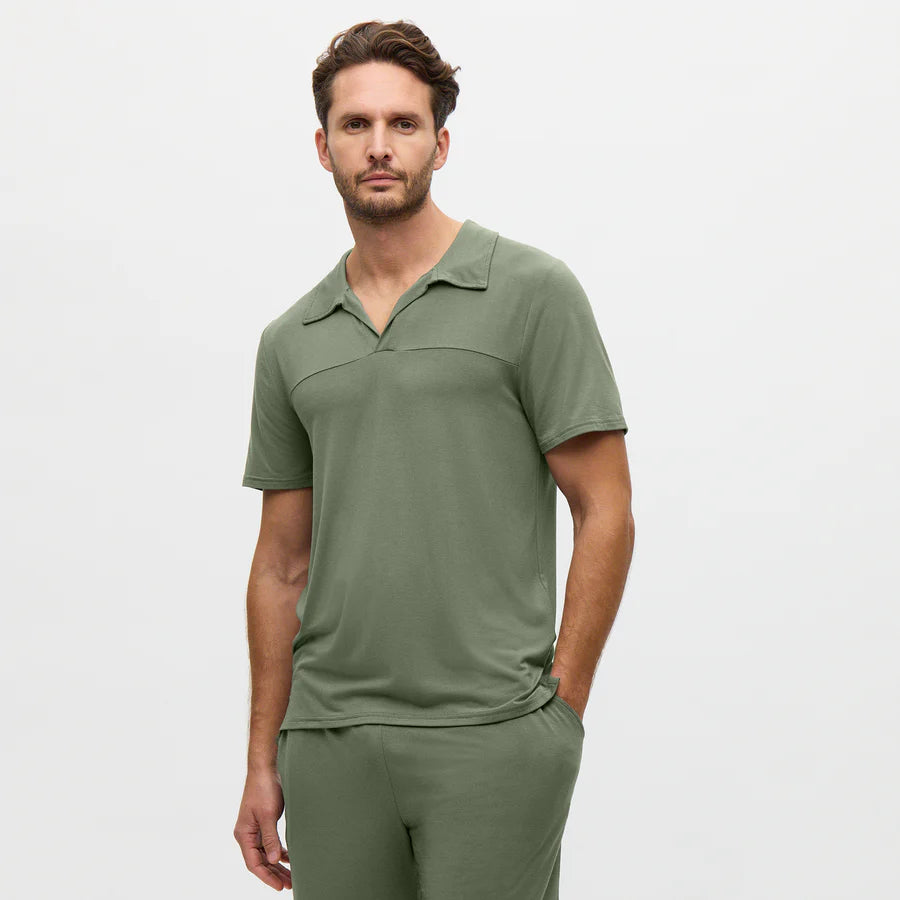 Man wearing a green polo shirt and pants on a white background