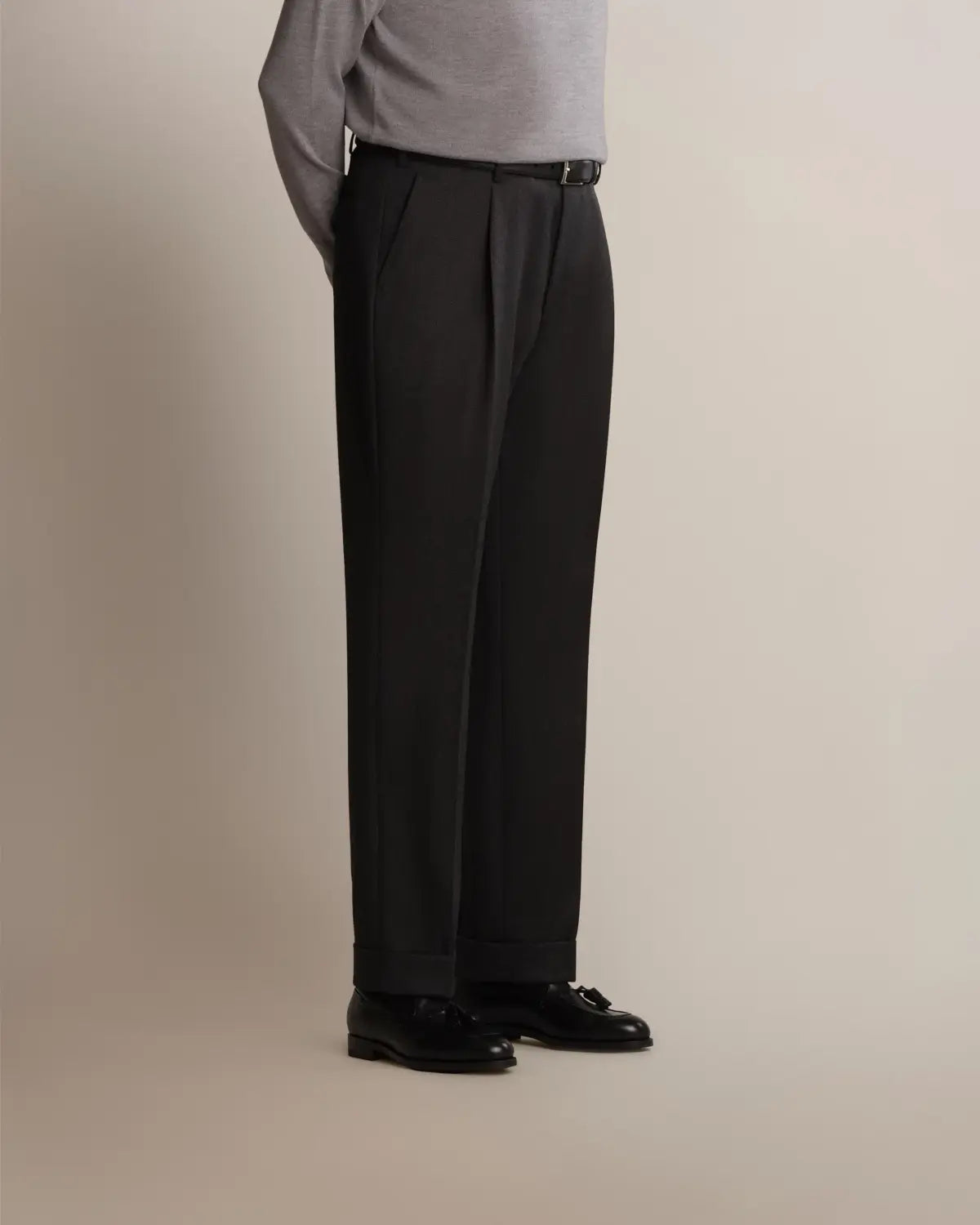 Charcoal Grey Straight Leg Pleated VBC Covert Wool Trousers by Cavour in charcoal grey with a straight-leg cut, subtle waist pleats, and cuffed hems, worn with a thin black belt and black leather tassel loafers against a neutral background. , available at Richard Gelding Mayfair