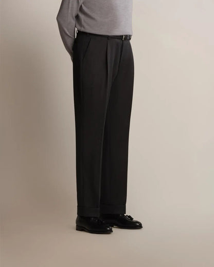 Charcoal Grey Straight Leg Pleated VBC Covert Wool Trousers by Cavour in charcoal grey with a straight-leg cut, subtle waist pleats, and cuffed hems, worn with a thin black belt and black leather tassel loafers against a neutral background. , available at Richard Gelding Mayfair