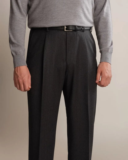 Cavour Charcoal Grey Straight Leg Pleated VBC Covert Wool Trousers in charcoal grey with front pleats and a straight-leg fit, worn with a thin black leather belt and a light grey crewneck sweater against a plain, neutral background. , available at Richard Gelding Mayfair
