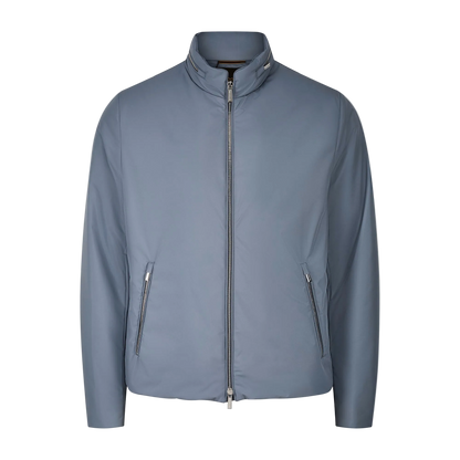 The Moorer Navy Blueberry Nylon Alcide Blouson is a men’s lightweight jacket with a stand collar, front zipper closure, two angled zippered pockets, long sleeves, and a smooth minimalist finish against a plain white background. , available at Richard Gelding Mayfair